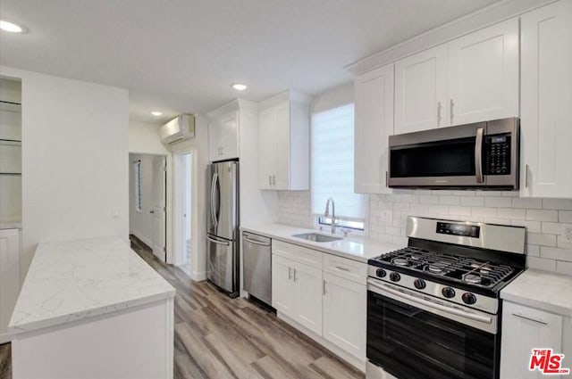 kitchen with white cabinetry, light hardwood / wood-style flooring, and stainless steel appliances