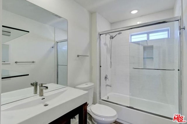 full bathroom with toilet, vanity, and shower / bath combination with glass door