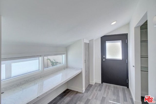 mudroom with wood-type flooring and lofted ceiling