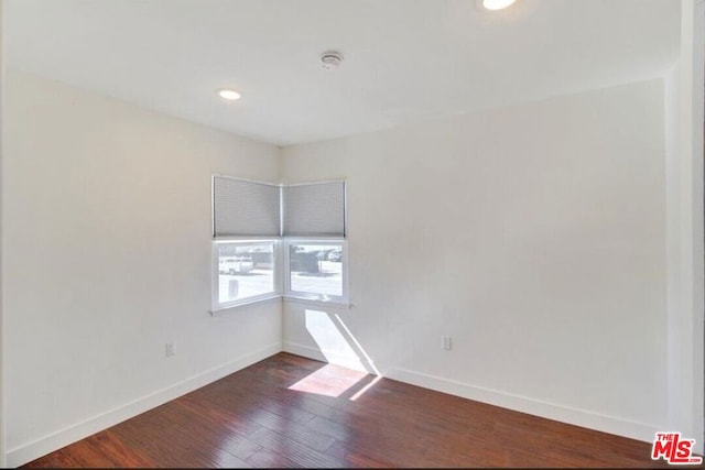 spare room featuring dark wood-type flooring