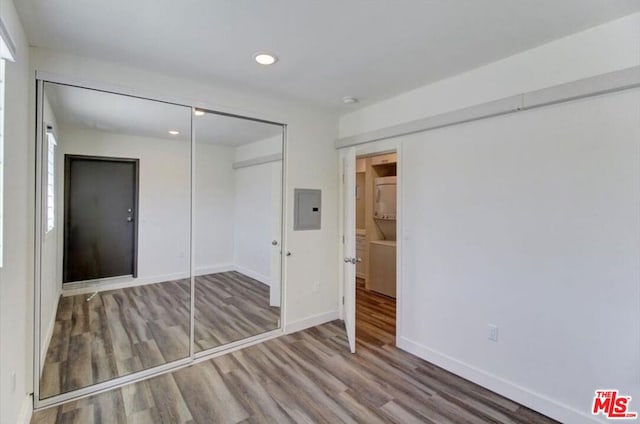 unfurnished bedroom featuring a closet, hardwood / wood-style floors, and electric panel