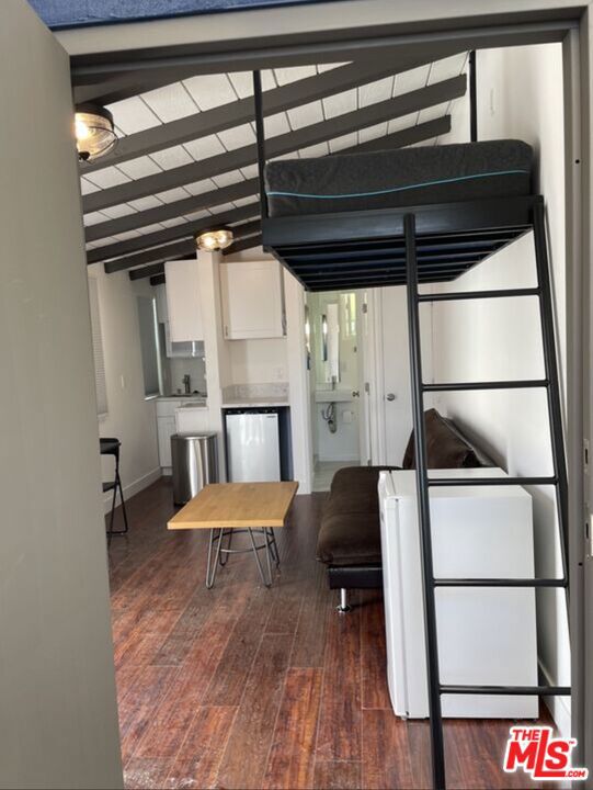 bedroom featuring lofted ceiling with beams and dark wood-type flooring