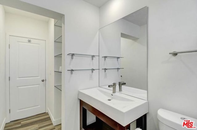 bathroom with toilet and hardwood / wood-style floors