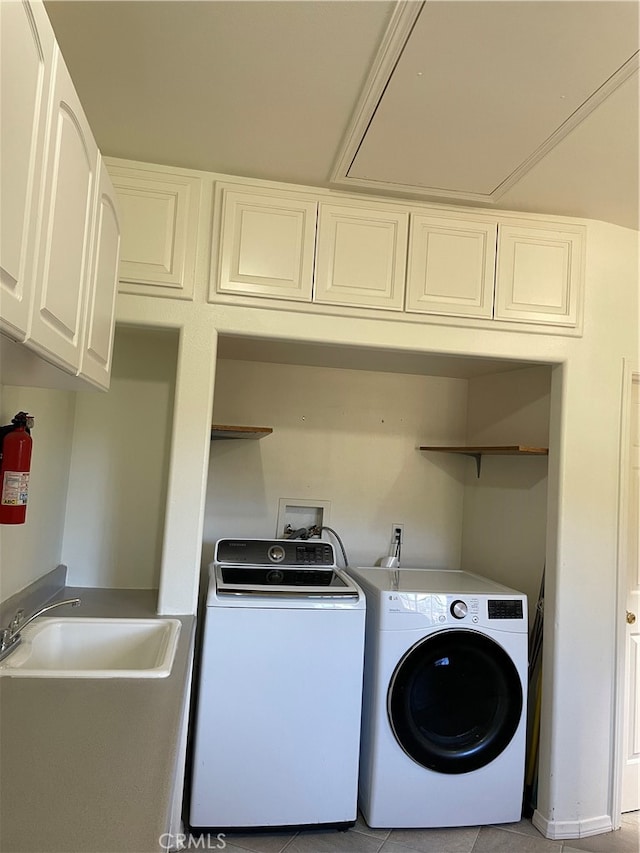 washroom with cabinets, light tile patterned flooring, sink, and washing machine and clothes dryer