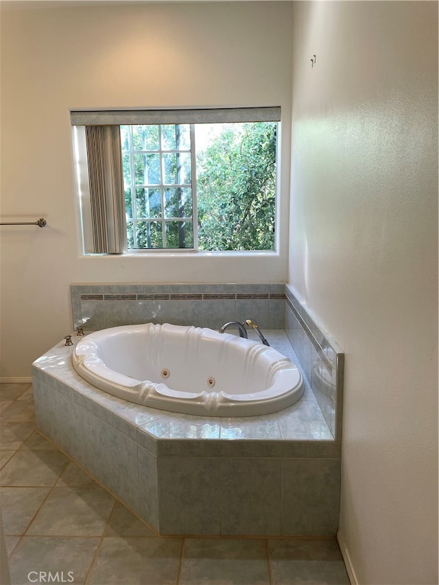 bathroom with tile patterned floors and tiled bath