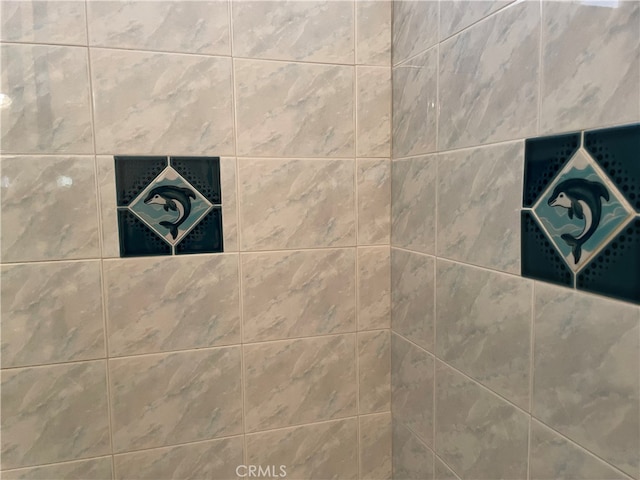 interior details featuring tiled shower