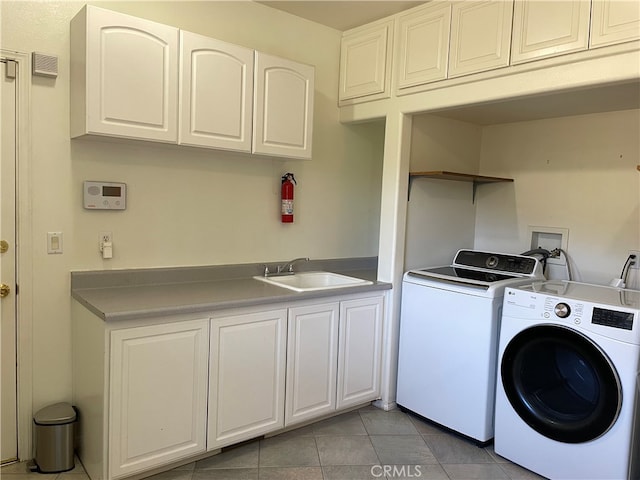 clothes washing area featuring cabinets, independent washer and dryer, sink, and light tile patterned flooring