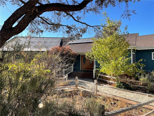 view of front of property featuring solar panels