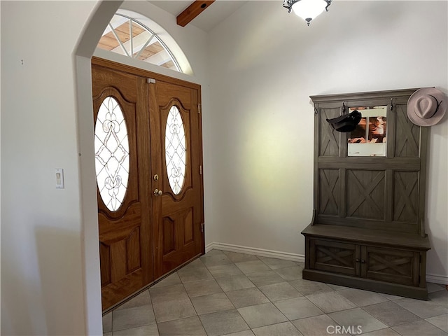 tiled entryway with lofted ceiling with beams