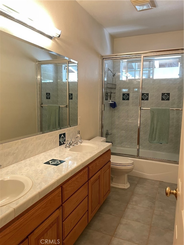 full bathroom featuring vanity, shower / bath combination with glass door, toilet, and tile patterned floors