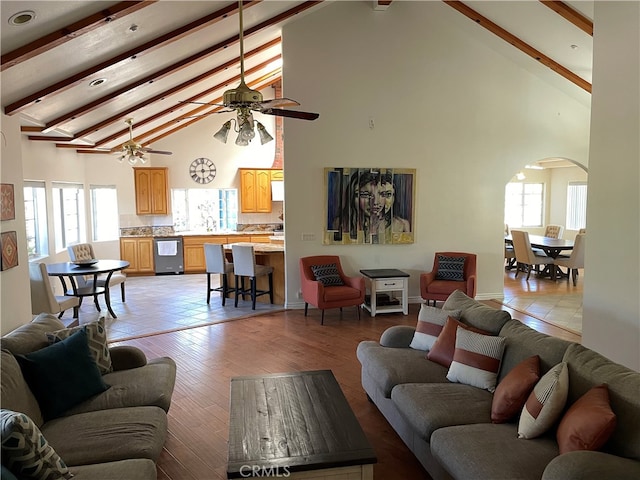 living room with high vaulted ceiling, a healthy amount of sunlight, and beam ceiling