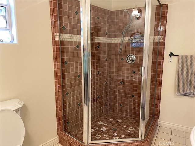 bathroom featuring toilet, tile patterned flooring, and a shower with door