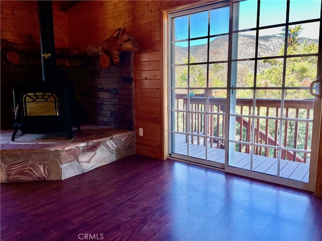 living room featuring wood walls, a wood stove, and hardwood / wood-style floors