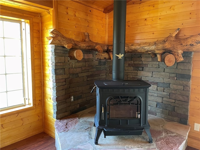 room details featuring wooden ceiling, hardwood / wood-style floors, a wood stove, and wood walls