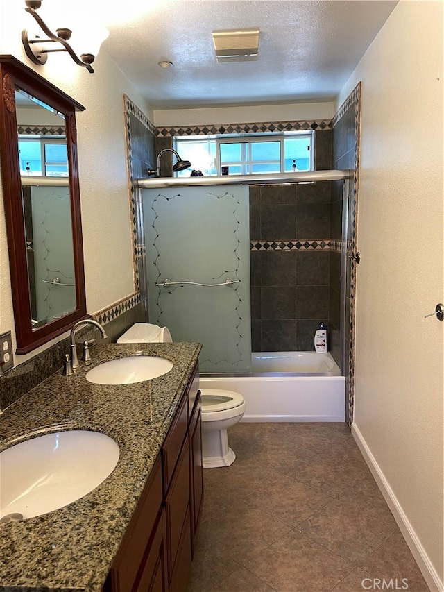 full bathroom featuring vanity, toilet, tiled shower / bath combo, and a textured ceiling