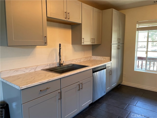 kitchen featuring stainless steel dishwasher, sink, dark tile patterned floors, and gray cabinets