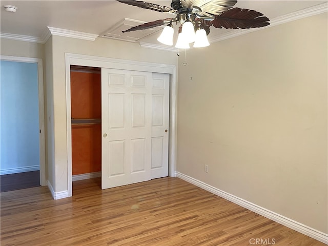 unfurnished bedroom with a closet, ornamental molding, hardwood / wood-style flooring, and ceiling fan