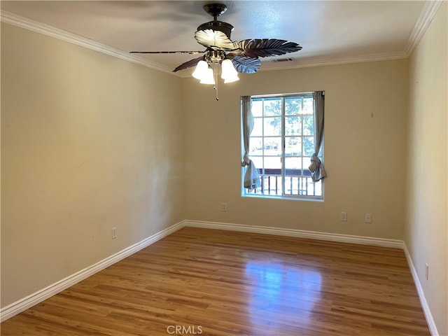 empty room with crown molding, hardwood / wood-style flooring, and ceiling fan