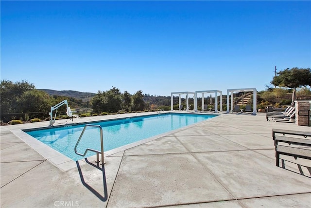 view of pool with a mountain view and a patio