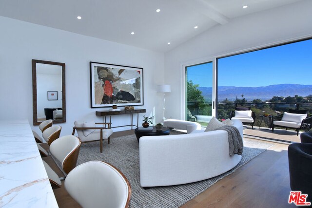 living room featuring a mountain view, hardwood / wood-style flooring, and lofted ceiling with beams