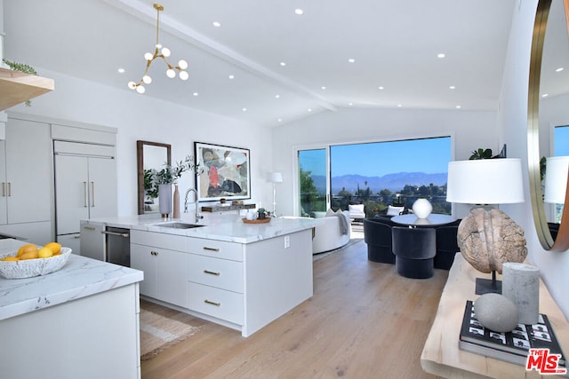 kitchen with white cabinetry, a center island with sink, paneled fridge, decorative light fixtures, and vaulted ceiling with beams