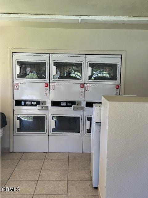 interior details featuring stacked washer / dryer and tile patterned flooring