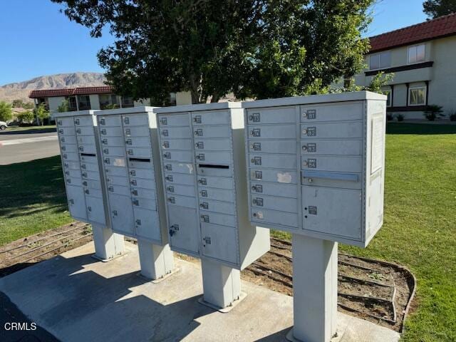 view of home's community featuring mail boxes, a mountain view, and a lawn