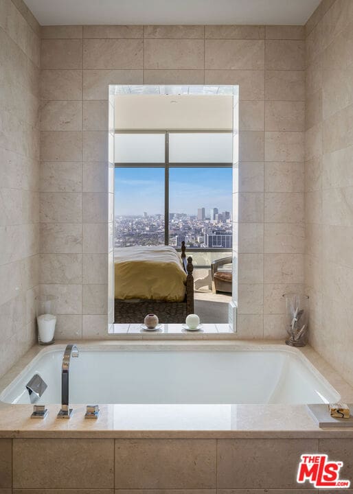 bathroom with tiled bath and tile walls