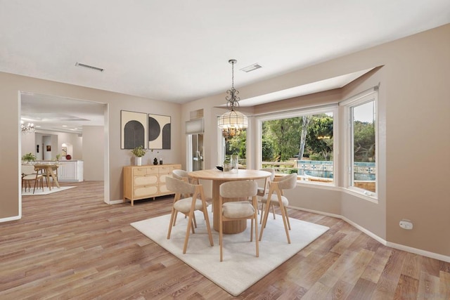 dining area featuring light hardwood / wood-style floors and an inviting chandelier