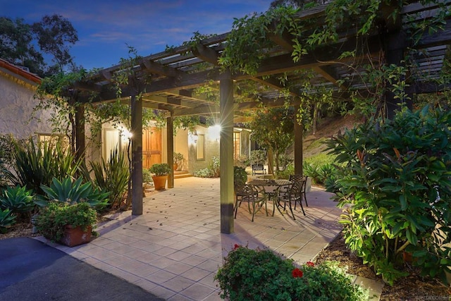 patio terrace at dusk featuring a pergola