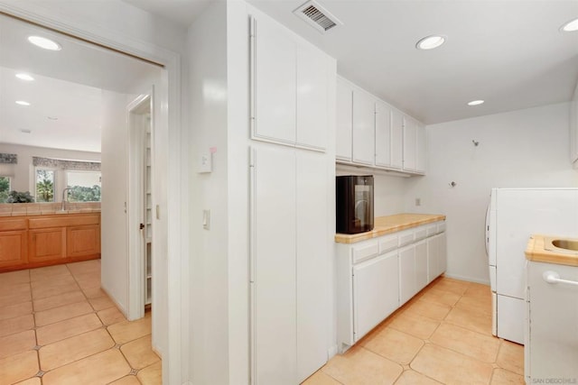 kitchen with white cabinetry, sink, and light tile patterned floors