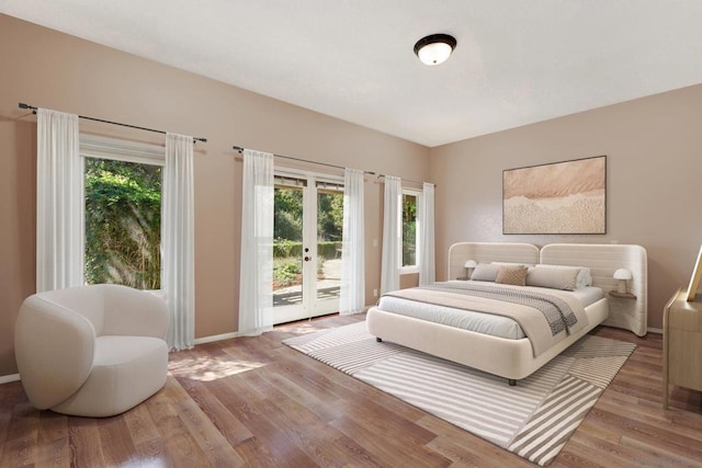 bedroom featuring hardwood / wood-style flooring, access to exterior, french doors, and multiple windows