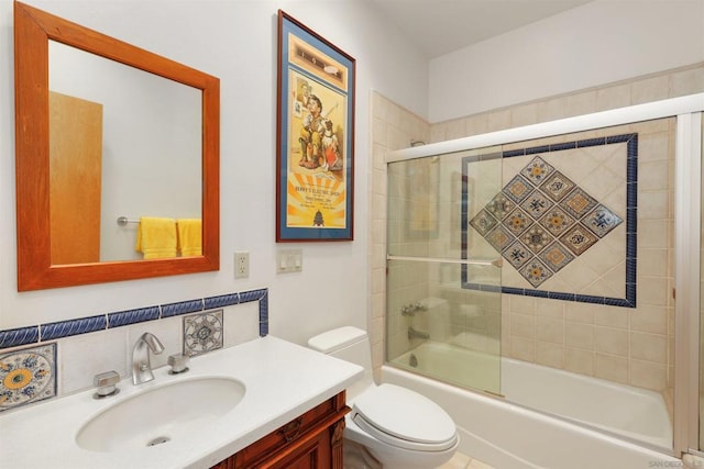 full bathroom with combined bath / shower with glass door, vanity, and toilet