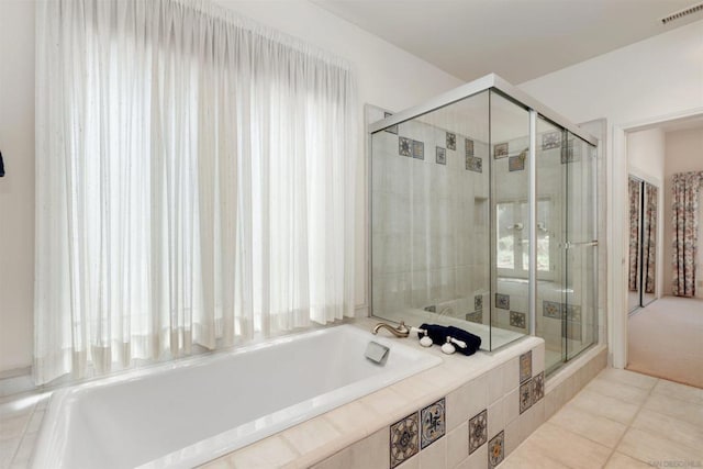 bathroom featuring tile patterned flooring and shower with separate bathtub