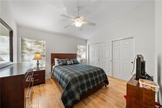 bedroom with vaulted ceiling, light hardwood / wood-style flooring, a closet, and ceiling fan