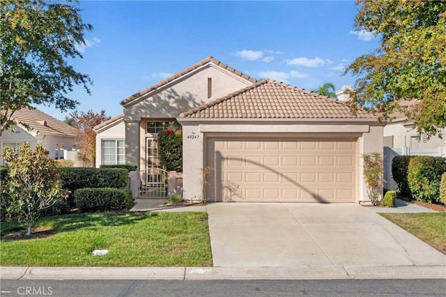 mediterranean / spanish-style house featuring a garage and a front lawn