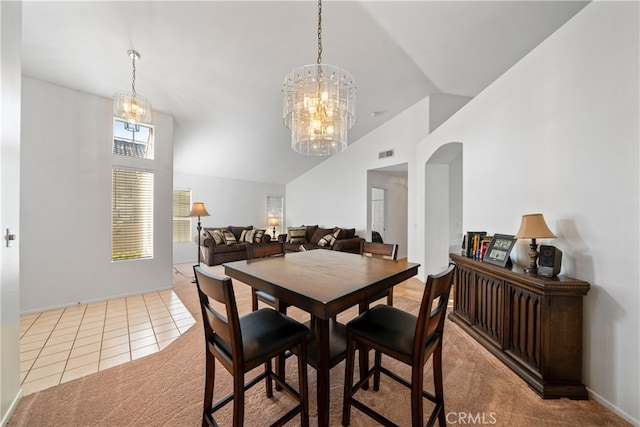 dining area with vaulted ceiling, an inviting chandelier, and tile patterned flooring