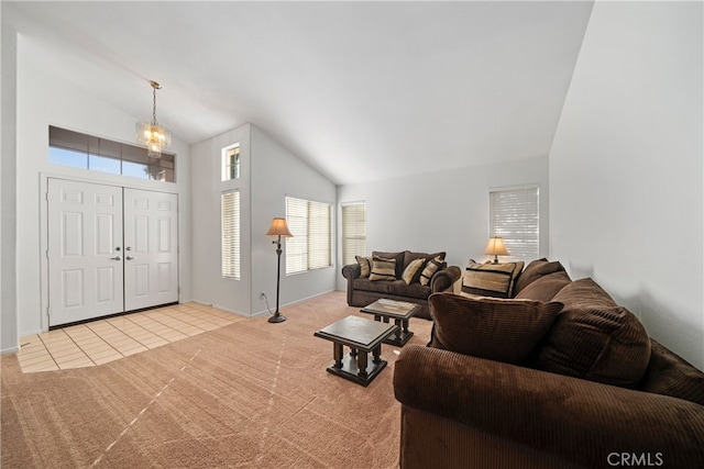 carpeted living room with a chandelier and high vaulted ceiling