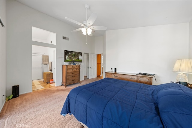 carpeted bedroom with ceiling fan, a towering ceiling, and ensuite bathroom