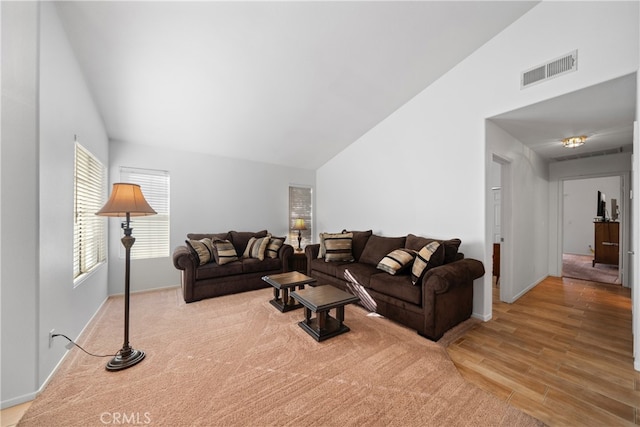 living room featuring vaulted ceiling and light hardwood / wood-style flooring