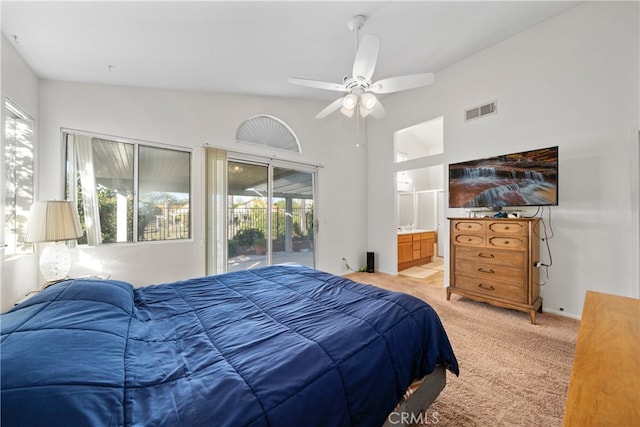 carpeted bedroom featuring ceiling fan, ensuite bath, multiple windows, and access to exterior