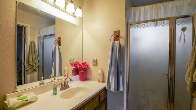 bathroom featuring vanity and an enclosed shower