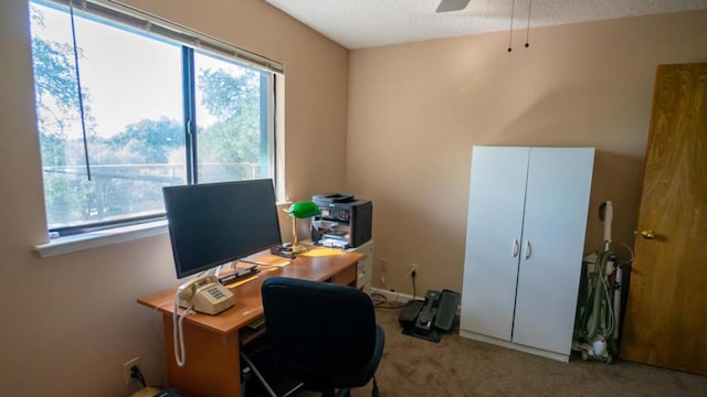 carpeted office space with a textured ceiling and ceiling fan