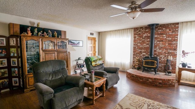 living area featuring a wood stove, dark hardwood / wood-style floors, and a textured ceiling