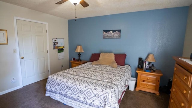 bedroom with dark colored carpet, a textured ceiling, and ceiling fan