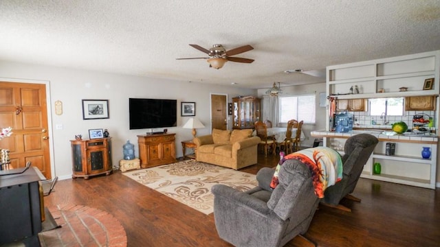 living room with ceiling fan, a textured ceiling, and dark hardwood / wood-style flooring