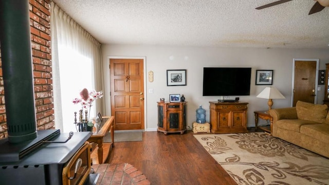 living room featuring ceiling fan, a textured ceiling, and dark hardwood / wood-style floors