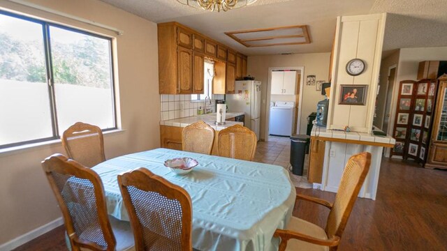 dining room featuring washer / dryer and dark wood-type flooring