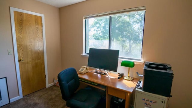 office space with plenty of natural light and dark colored carpet