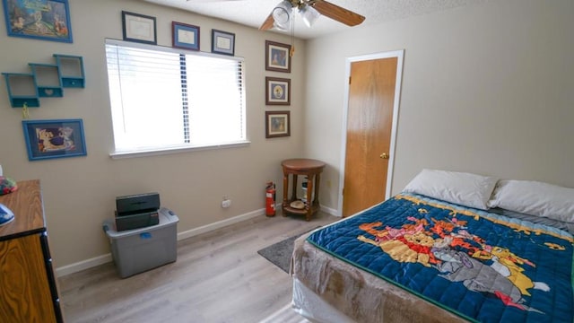 bedroom with a textured ceiling, light wood-type flooring, and ceiling fan